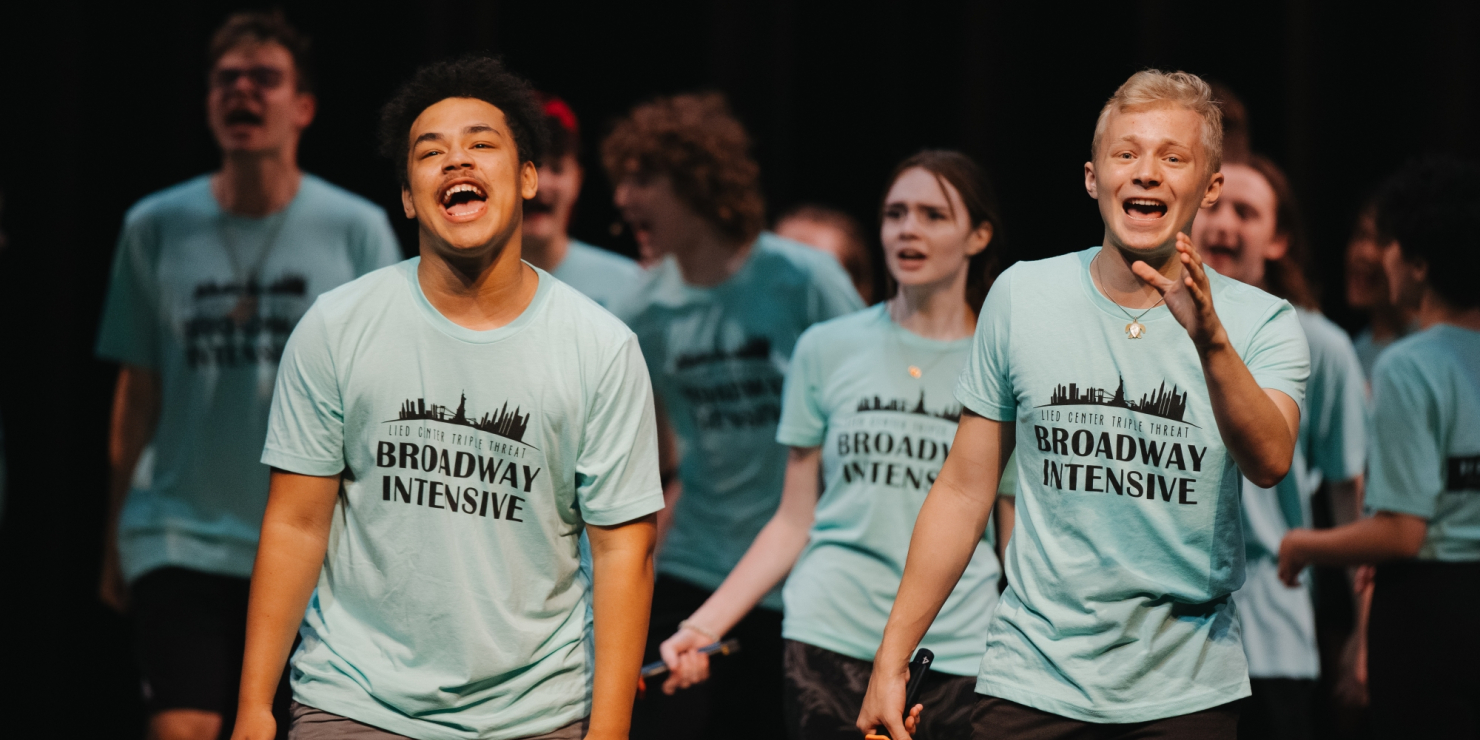 Young artists singing in blue shirts.