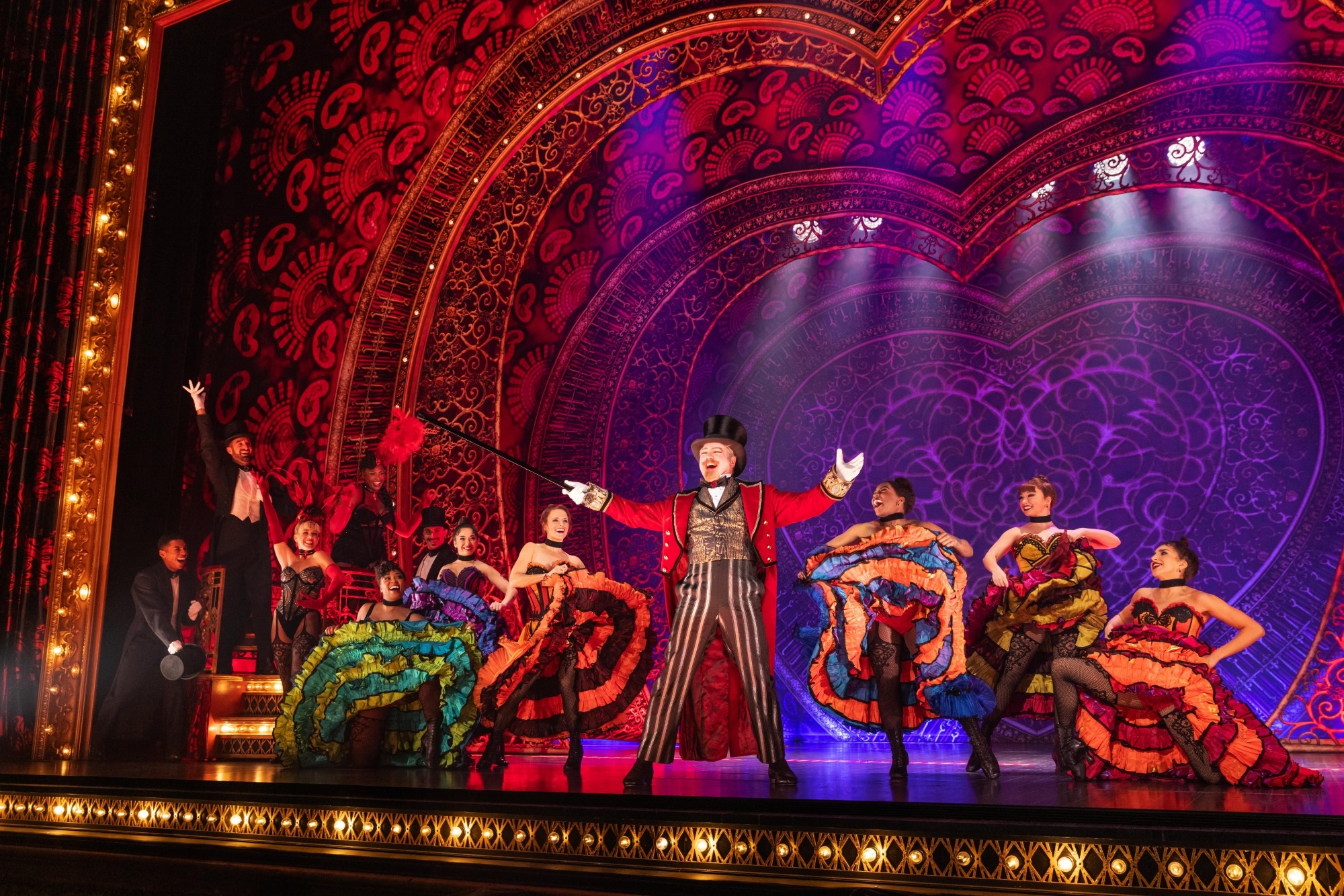 Image of Moulin Rouge with Harold Zidler on stage in a tuxedo. 