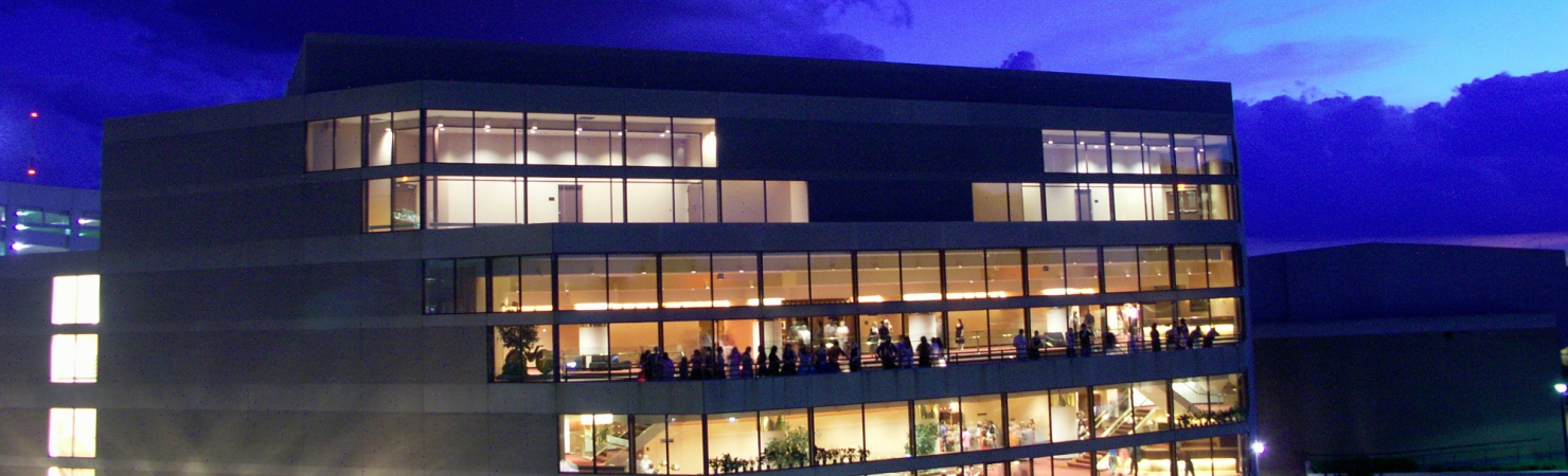 Image of the Lied Center building taken from the roof of a nearby building at dusk with a brilliant blue sky.