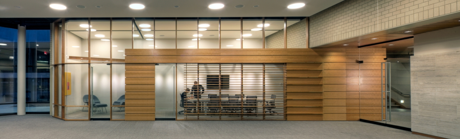 Image of the Lied Commons showing an empty Multipurpose Room and two staff members working at the table in Boardroom